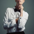 Simplicity is the ultimate sophistication. Studio shot of a young woman wearing a shirt and bow tie against a gray