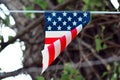 Simplified flag with American colors with red stripes and white stars on blue background hangingfrom line