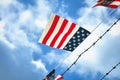 Flag with American national colors with red stripes and white stars on blue background blowing in the wind hanging next
