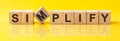 simplify word is made of wooden building blocks lying on the yellow table, concept Royalty Free Stock Photo