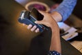 Simplifying spending. a woman paying using NFC technology in a cafe.