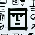 A simplistic, hand-drawn face, a stylized representation of a human face, with a rectangular shape. The face has a neutral