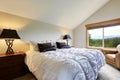 Simplistic master bedroom with grey bedding, black nightstands and mountain view.