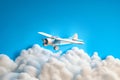 A simplistic white children\'s toy aeroplane flying above white fluffy clouds in a clear blue sky with copy space Royalty Free Stock Photo