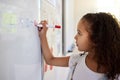 This is simply the best way for little kids to learn. a little girl doing maths on a board in a classroom. Royalty Free Stock Photo