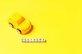 Simply design yellow toy car and inscription DELIVERY word isolated on yellow colorful background. Internet shopping online