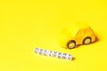 Simply design yellow toy car and inscription DELIVERY word isolated on yellow colorful background. Internet shopping online