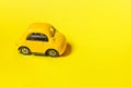 Simply design yellow vintage retro toy car isolated on yellow background. Automobile and transportation symbol. City traffic