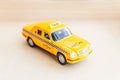 Simply design yellow vintage retro toy car Taxi Cab model on wooden background. Automobile and transportation symbol. City traffic Royalty Free Stock Photo