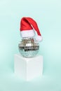Simply minimal composition disco ball in Santa hat and cube shapes geometric form podium isolated blue pastel background. Royalty Free Stock Photo
