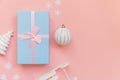 Simply minimal composition winter objects ornament ball fir tree sled gift box isolated on pink pastel trendy background