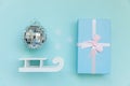 Simply minimal composition winter objects ornament ball sled gift box isolated on blue pastel trendy background