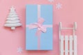 Simply minimal composition winter objects ornament fir tree sled gift box isolated on pink pastel trendy background