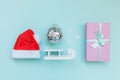 Simply minimal composition winter objects ornament Santa hat sled gift box isolated on blue pastel trendy background