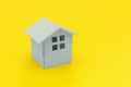 Simply minimal design with miniature white toy house isolated on yellow colourful trendy modern fashion background Royalty Free Stock Photo