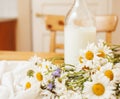 Simply stylish wooden kitchen with bottle of milk and glass on table, summer flowers camomile, healthy food moring Royalty Free Stock Photo