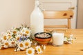 Simply stylish wooden kitchen with bottle of milk and glass on table, summer flowers camomile, healthy foog moring Royalty Free Stock Photo