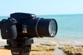 A Nikon digital camera on a tripod filming and recording a natural scene on a beach of South Sinai in front of the red sea