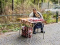 An elderly gypsy sells a raspberry at the entrance to the park is located not far from the Pelesh castle in Sinaia in Romania