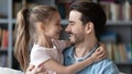 Sincere adorable beautiful small preschool kid girl cuddling father.