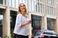 Sincere laughing young blond woman against urban city background