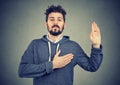 Sincere man swearing with hand on heart Royalty Free Stock Photo