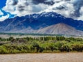 Sindhu River in Leh, India flows under a bright blue sky with scattered clouds. Royalty Free Stock Photo