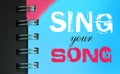 Sing your song words on sky blue page of copybook in white and pink. Music concept