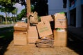 Piles of corrugated cardboard boxes collection, some flattened, stacked neatly by the roadside in an HDB heartland neighbourhood.