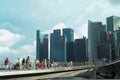 Singapore, August 19, 2023-Group of people walking on the bridge with crowded of high modern buildings in background