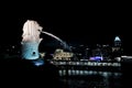 Singapore:August 20, 2023- Side view of Merlion spraying the water with cityscape at night and lake in background