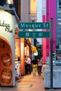 Street sign of Mosque St from the city in Singapore. People can seen exploring around it