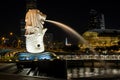 Merlion statue spraying the water from its mouth at Merlion Park in downtown core of Singapore at Marina Bay at at night time Royalty Free Stock Photo