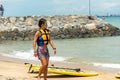 Singapore East Coast Park Beach. One Asian Chinese female wind surfer walking on beach after competition