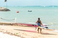 Singapore East Coast Park Beach. One Asian Chinese wind surfer carrying his equipment heading out to sea for training