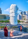 Singapore - Feb 25, 2020. Buddhist monks and nuns take pictures by famous Merlion fountain, symbol of Singapore, half