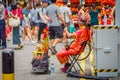 SINGAPORE, SINGAPORE - FEBRUARY 01, 2018: Elder street musician busking along a busy street during Chinese New Year in