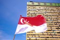 Singapore flag waving in the wind against background of peoples park old building; on bright beautiful sunny day with blue sky