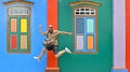 20.08.2017.Singapore, flying happy tourist in front of colorful facade of historic old building in Little India Royalty Free Stock Photo