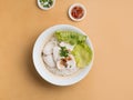 singapore food Sliced Fish Bee Hoon in bowl with soup, chili sauce and spring onion top view on wooden table Royalty Free Stock Photo