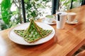 Singapore green pandan crispy waffle, green tea latte, heart latte and coffee served in white plate on wooden table