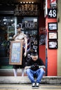 Singapore-21 JUL 2018:man sitting on the road side and playing hand phone