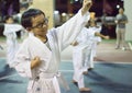 A white belt happy boy performing a high punch during a taekwondo training