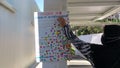 Asian woman pasting colourful building entry sticker on a Covid-19 sign notice