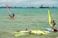 Singapore East Coast Park Beach. Asian sports man and women windsurfer windsurfing in the lagoon sea. Failed attempt to surf the s