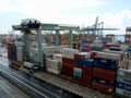 Containers stacked in the storage area next to a large crane that loads and unloads trucks at the Singapore container port