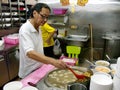 A man cooks in the restaurant of a typical Singapore food court or Hawker Royalty Free Stock Photo