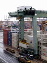 Vertical view of a large crane loading a container onto a truck at the Singapore container port