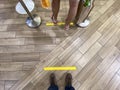 Queueing while maintaining social safe distancing measure in malls. Marked taped spots allocated for queueing; to maintain