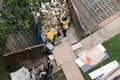 Singapore May2021 Workers unloading heaps of debris and construction waste from renovation of HDB flat into metal container for Royalty Free Stock Photo